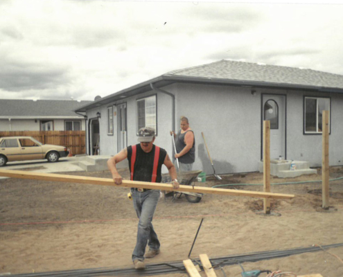 A family works on their self-help home in El Milagro. Courtesy of CRHDC.