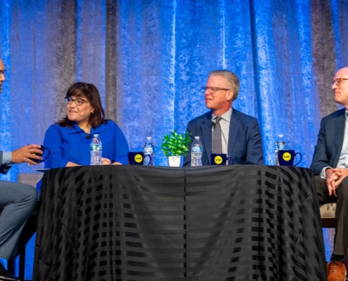 Four panelist discuss the importance of national intermediaries around a kitchen table at the National Rural Housing Conference