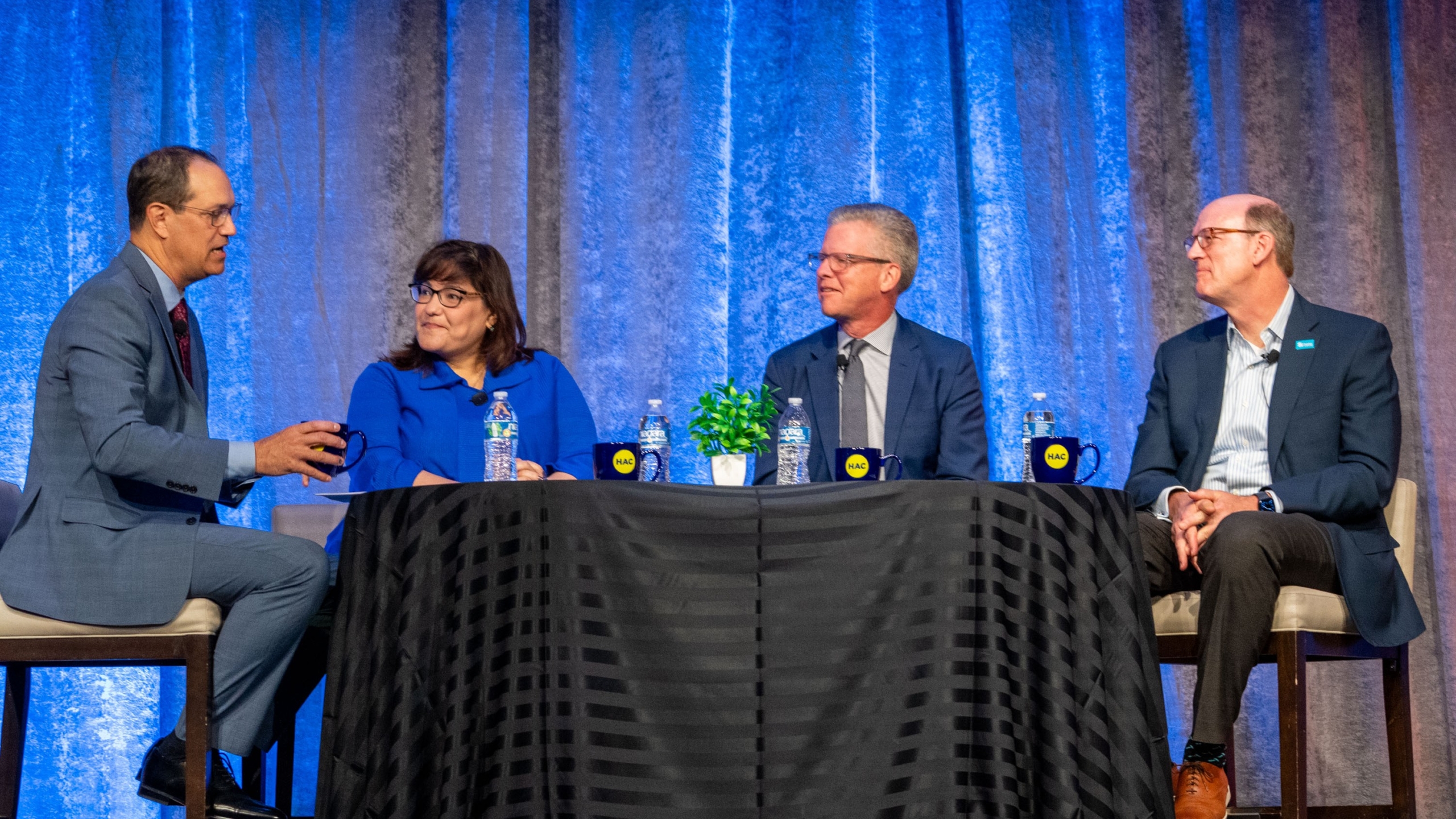 Four panelist discuss the importance of national intermediaries around a kitchen table at the National Rural Housing Conference