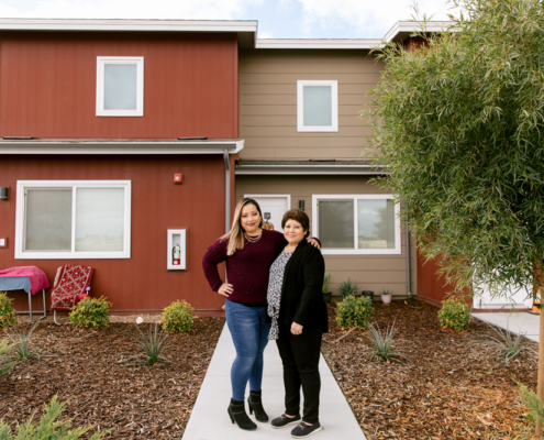 Claudia Miranda and her mother, Martha Baltazar, in front of Martha’s home at Rosaleda Village in Wasco, Calif.