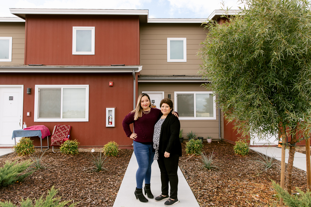 Claudia Miranda and her mother, Martha Baltazar, in front of Martha’s home at Rosaleda Village in Wasco, Calif.