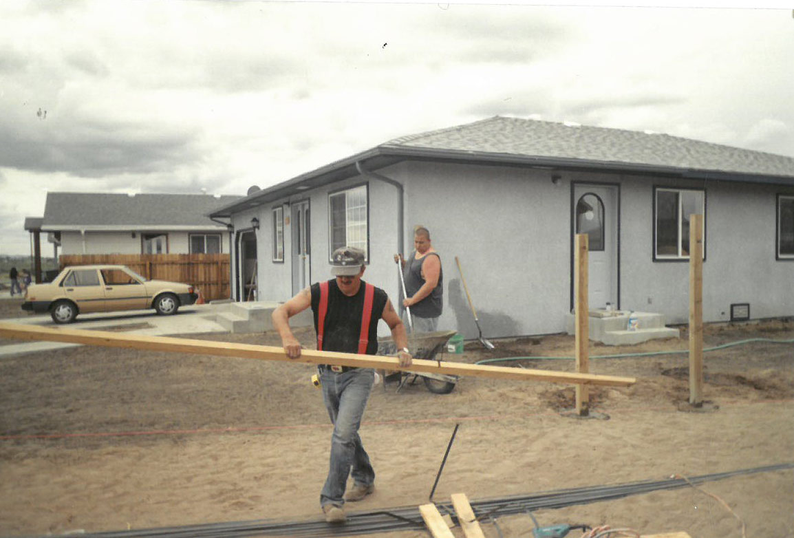 A family works on their self-help home in El Milagro. Courtesy of CRHDC.